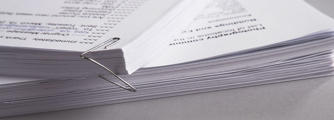 Stacks of papers held together by a paperclip