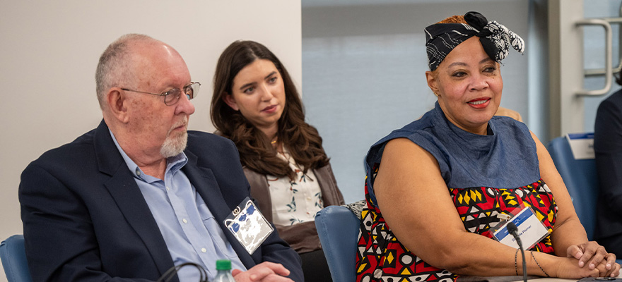 Three people sitting next to each other, taking part in a work event.
