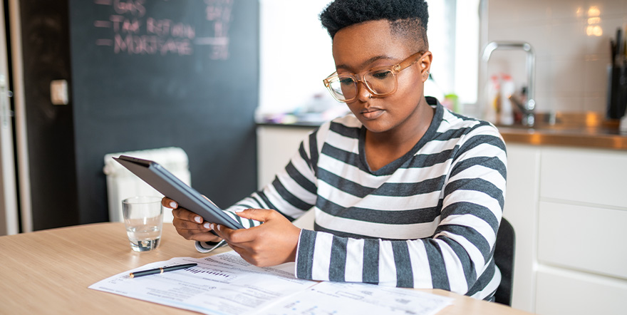 A student reviews bills and types on an iPad.