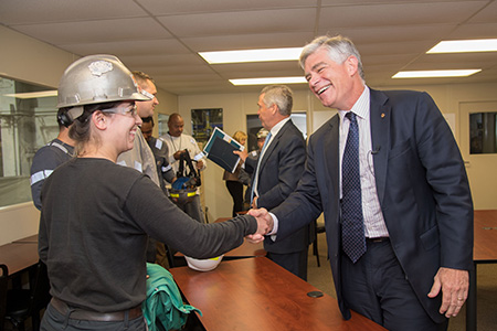 Two people shaking hands, with one of them wearing a hard hat