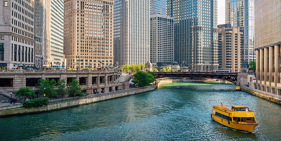 A tour boat navigates a river that runs through the city of Chicago.