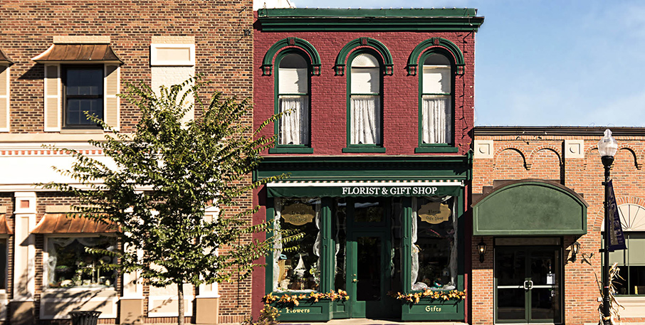 Row of small business store fronts, including a florist & gift shop