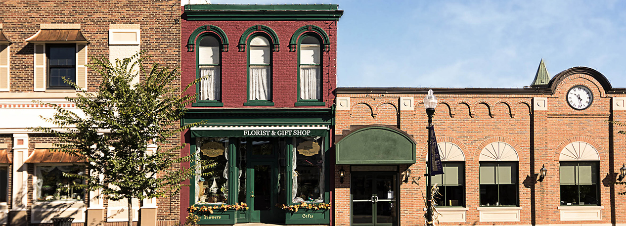 Row of small business store fronts, including a florist & gift shop