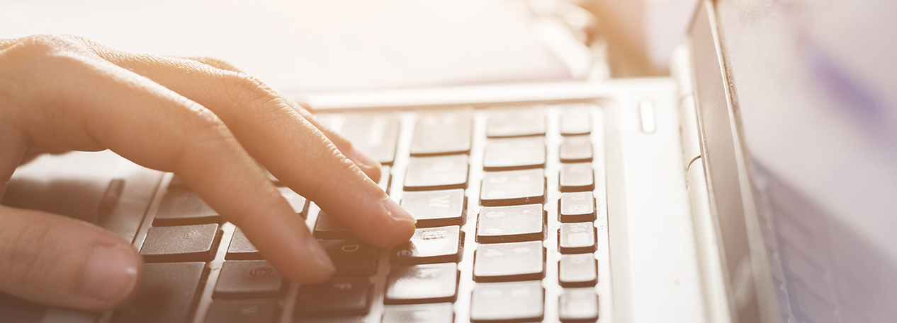 Close up of an individual typing on a computer keyboard