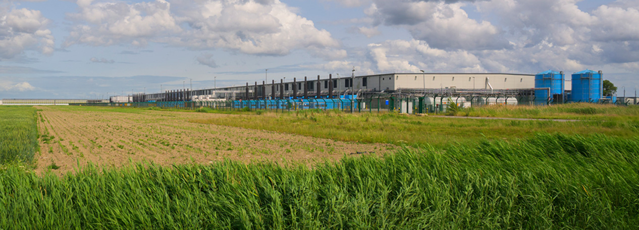 A grassy field next to a data center.