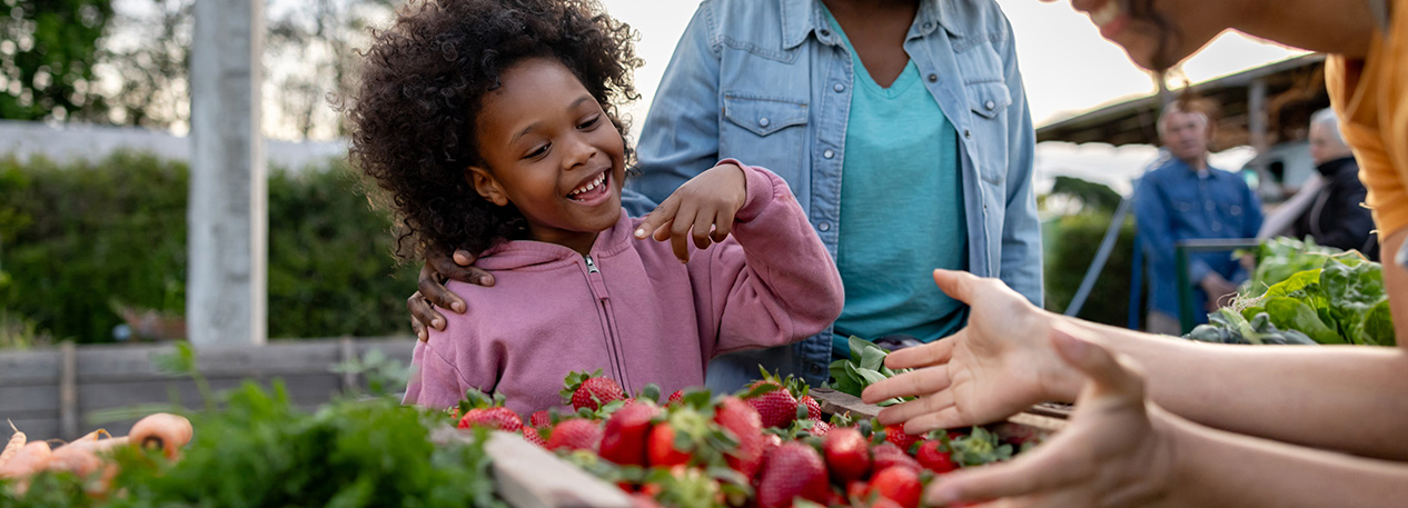 Young child with an adult at a farmers market