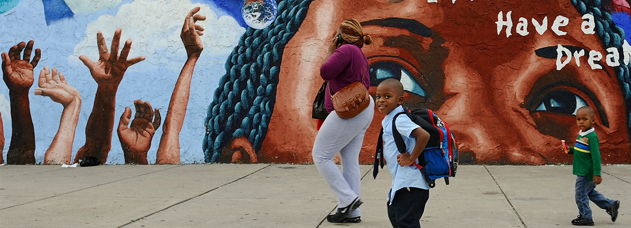 A family walks by a mural in Philadelphia.