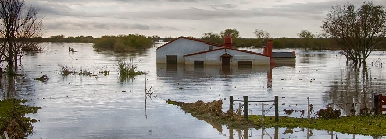 Image of a house and property in a rural area covered in flood waters.