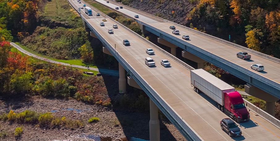 Cars and trucks driving on a highway among trees