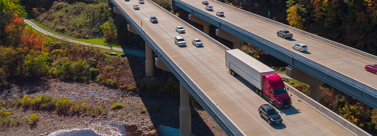 Cars and trucks driving on a highway among trees
