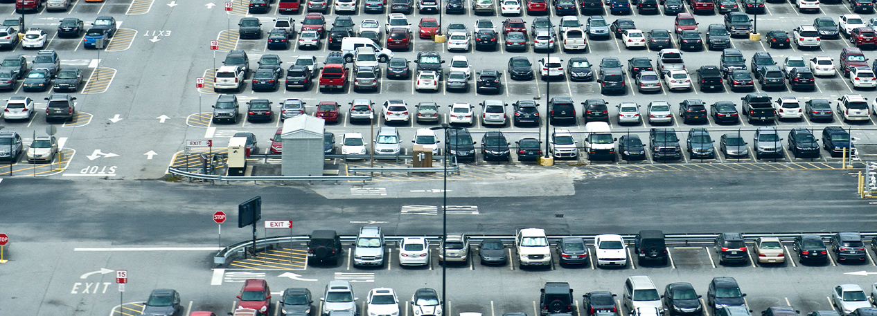 A large parking lot, filled with parked cars.