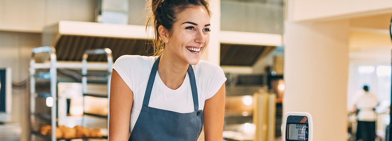 Woman in apron at counter in a restaurant