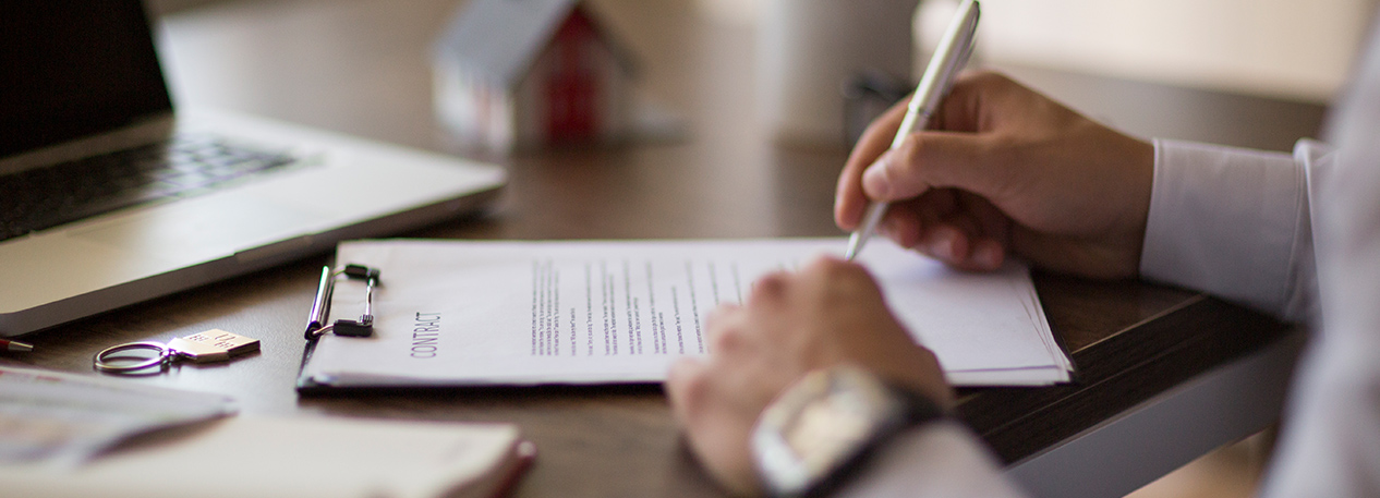 Man signing a document on a clipboard
