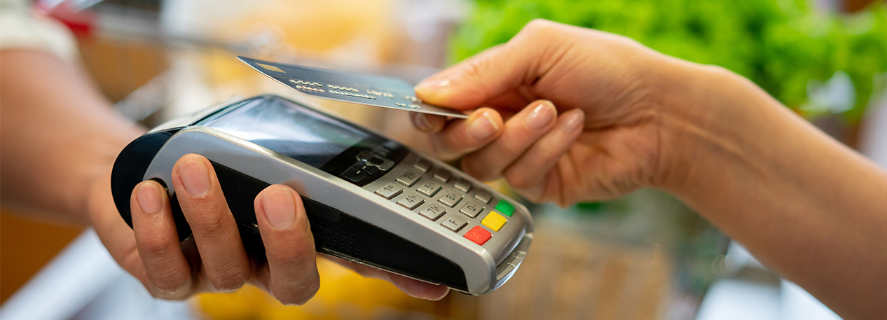Woman holding a credit card above a card reader
