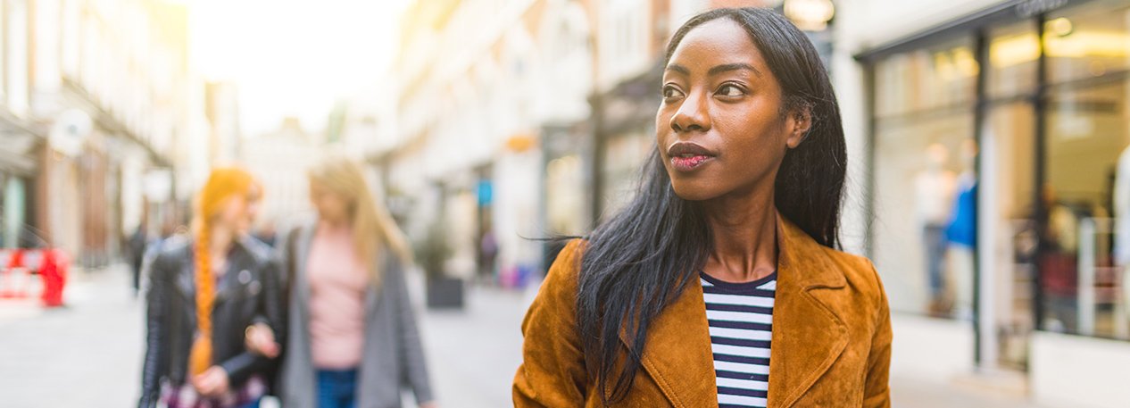 Woman walking down a row of shops
