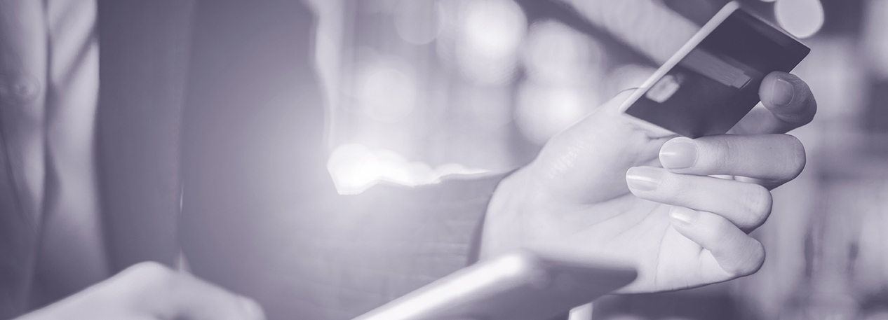 Woman holding a credit card in one hand and a cell phone in the other