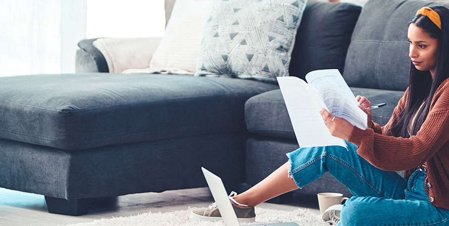 A woman looking through papers while sitting on the floor