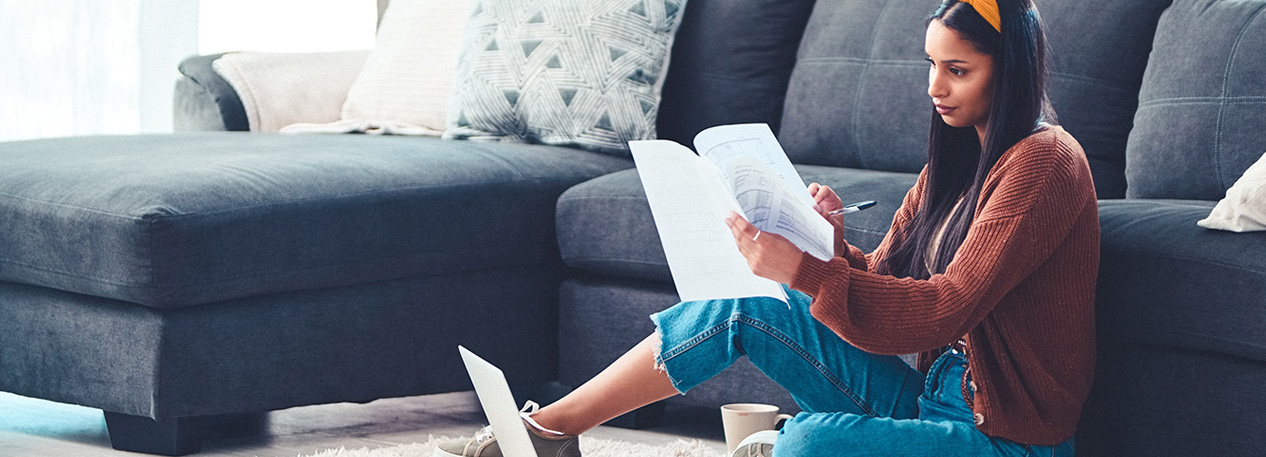 A woman looking through papers while sitting on the floor