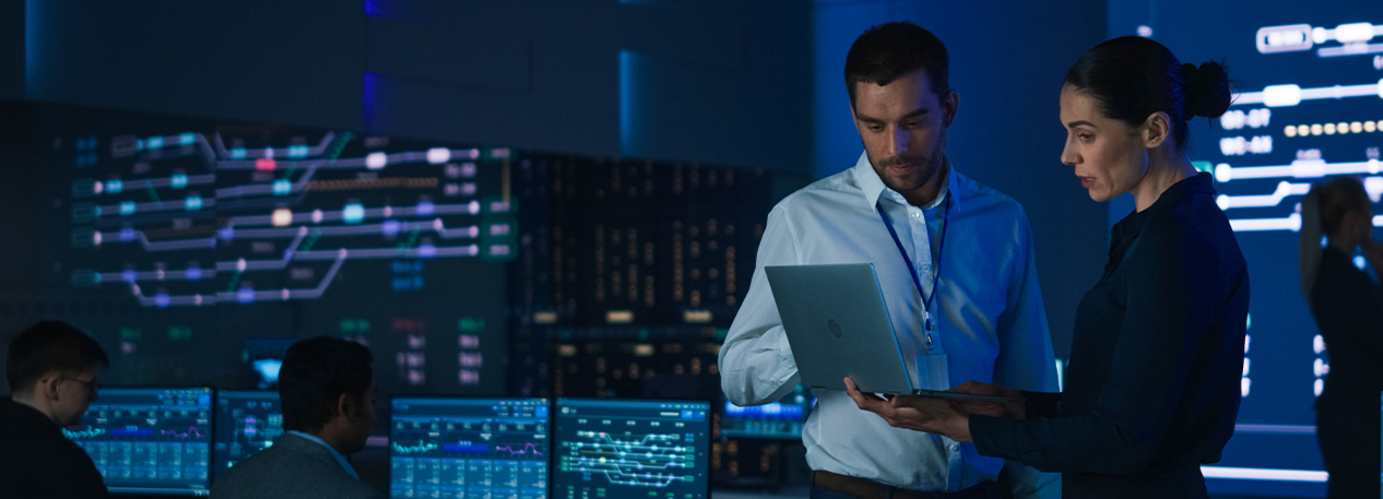 Two colleagues look at a computer in a technology lab.