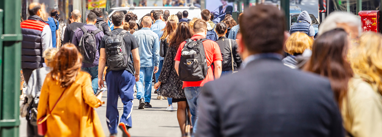 People are walking on a crowded city sidewalk.