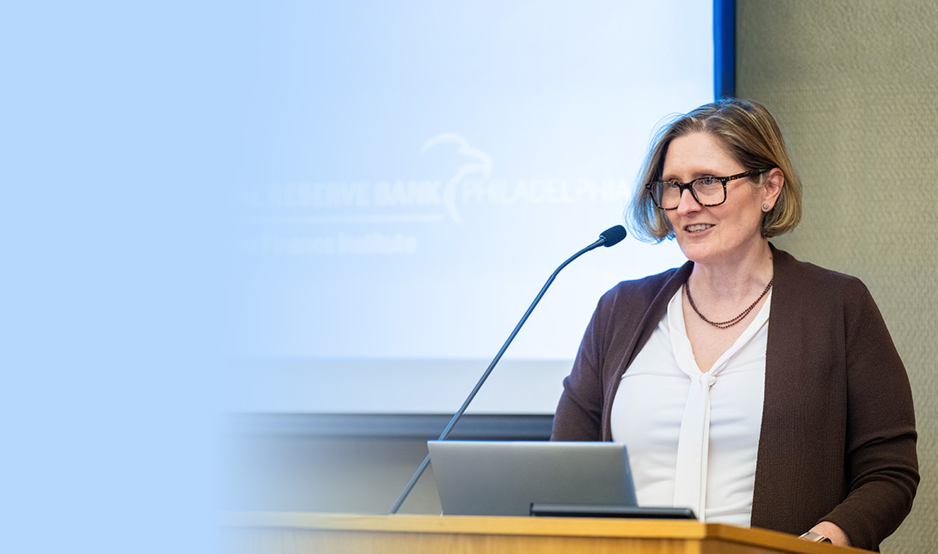 President Anna Paulson speaking at a podium.
