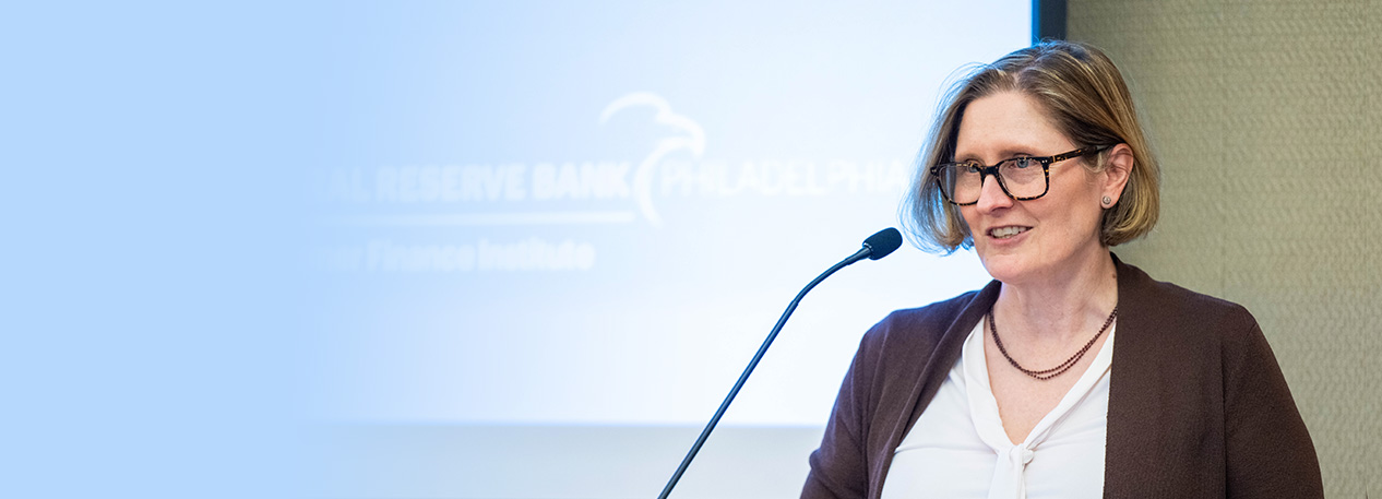 President Anna Paulson speaking at a podium.