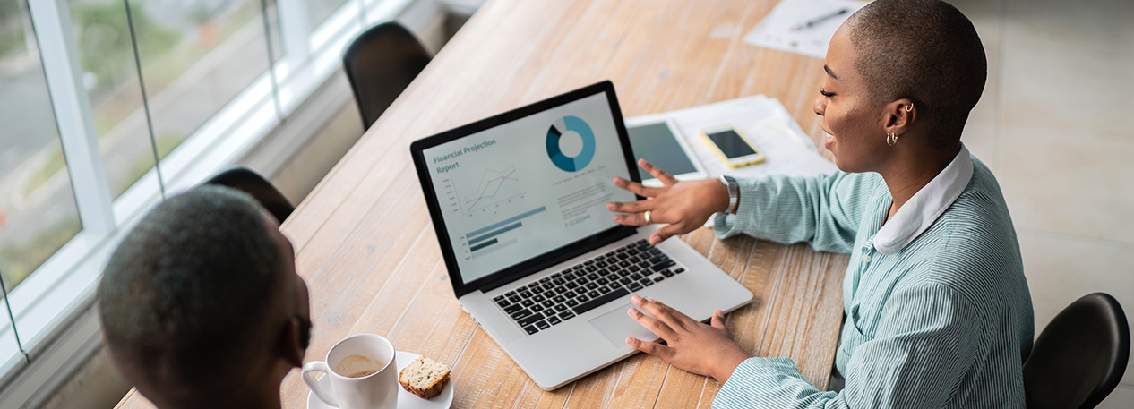 A modern woman reviews data on a laptop.