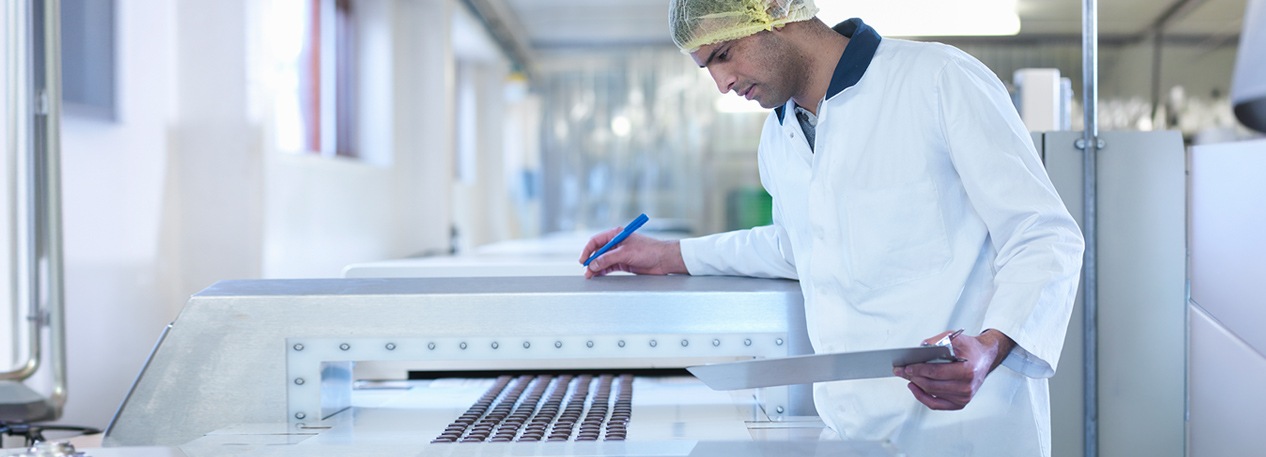 Someone inspecting a candy factory assembling line