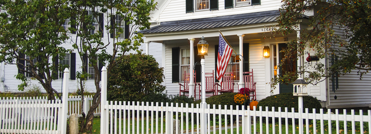 Fenced-in front yard of white house