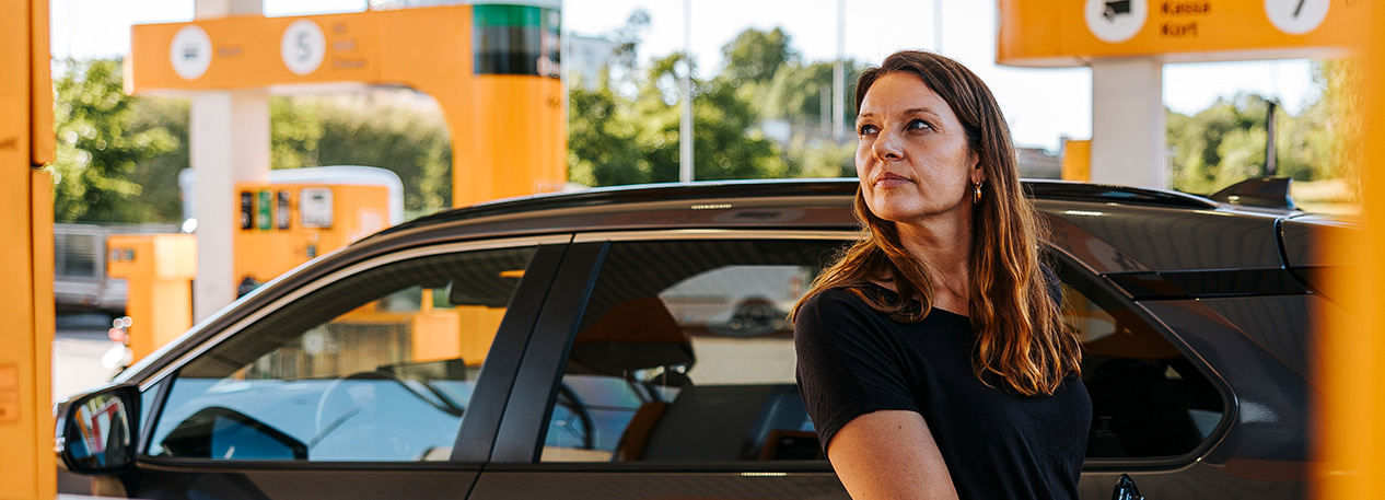 Woman filling her car gas tank at gas station
