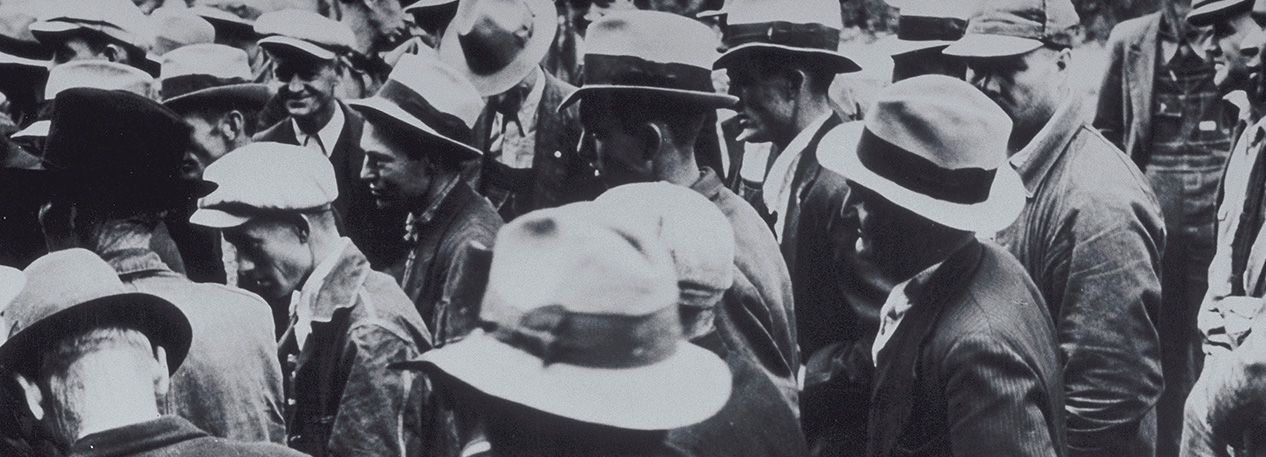 A black and white image of a crowd of men from the era of the Great Depression.