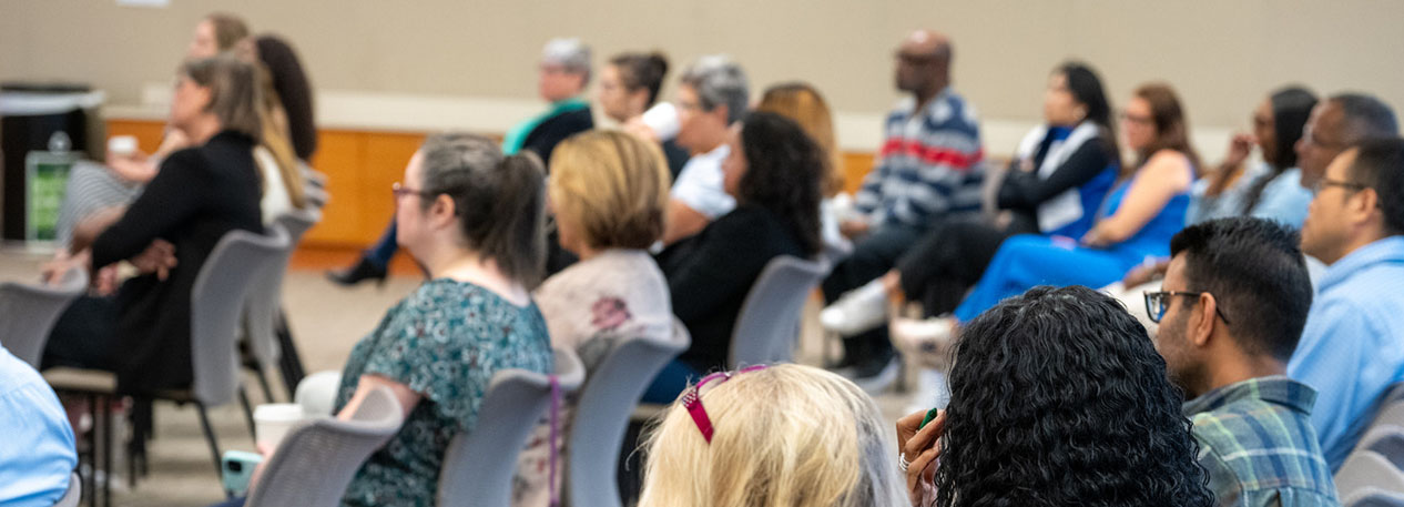 A group of meeting attendees sitting in rows.