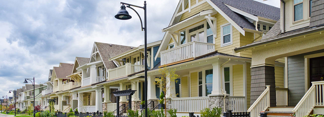 Row of gabled beach houses with large pillars and a second-floor balcony