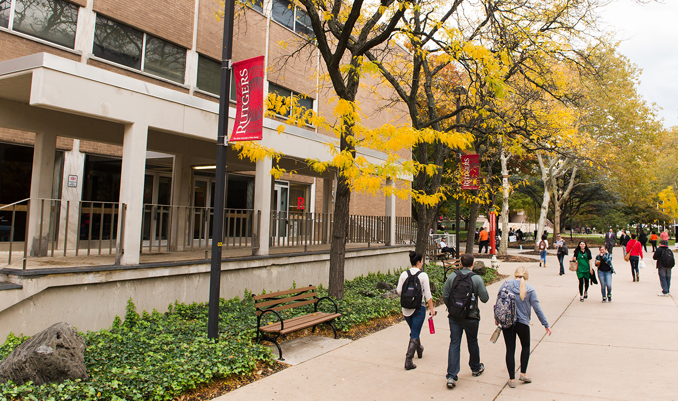 Three college students walk through campus in the fall.