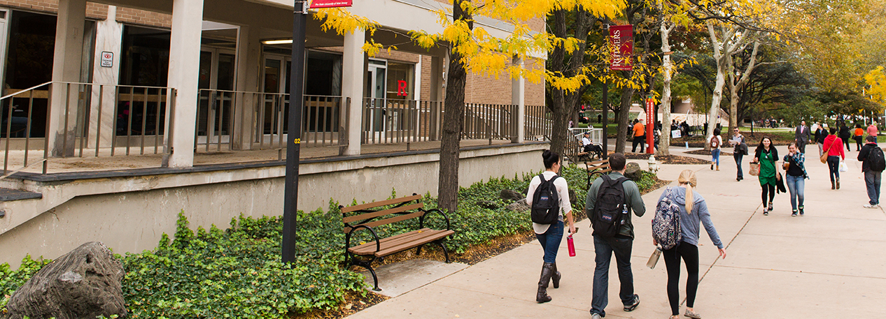 Three college students walk through campus in the fall.