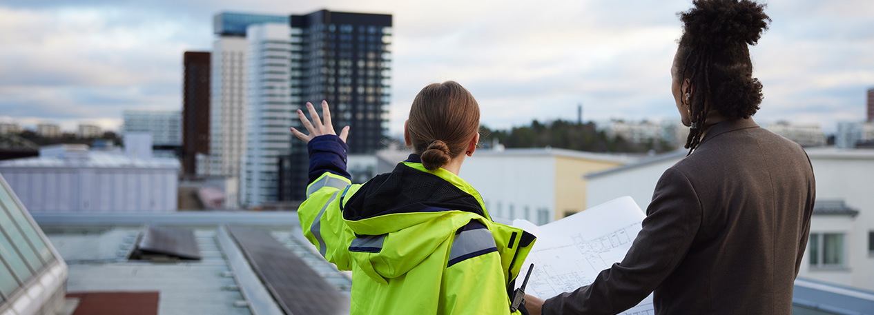 City planners in discussion as they stand on a roof.