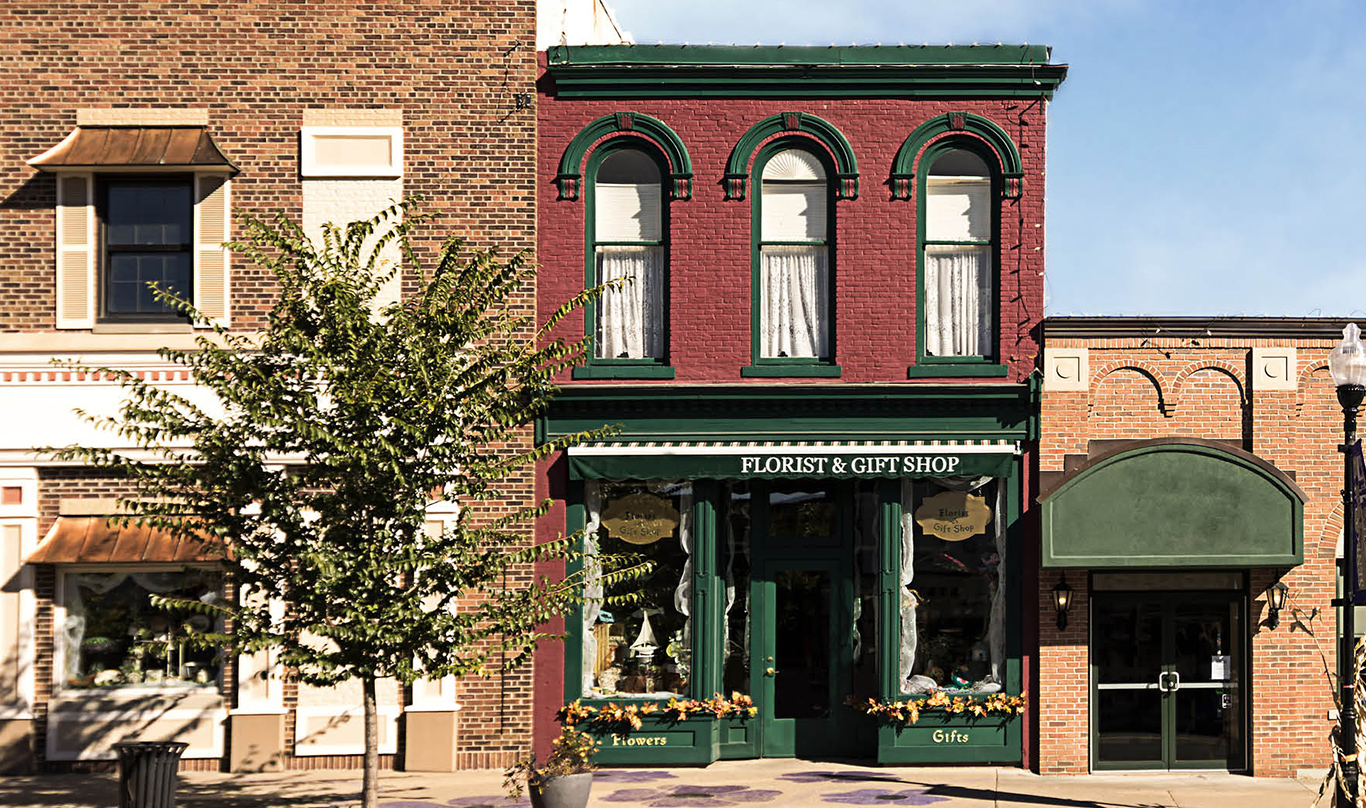 Row of small business store fronts, including a florist & gift shop