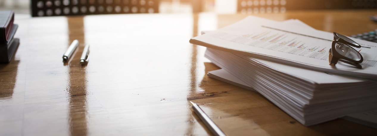 Documents and pens on a wooden desk