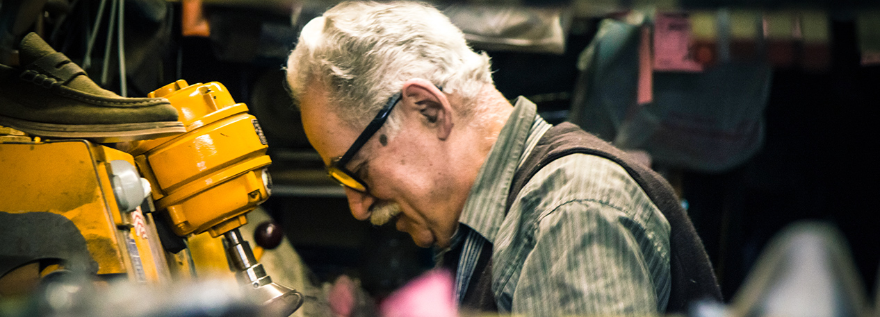 Older man with glasses working in a shoe repair shop