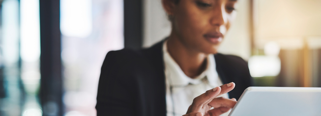 Woman in a dark blazer using a tablet computer