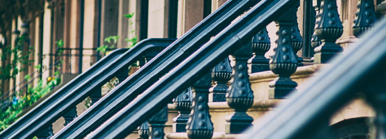 Row of painted metal bannisters going up the front steps to townhouses