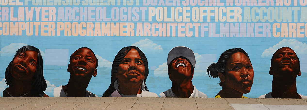 Mural on a wall depicting the heads of six people looking up at the names of various careers.