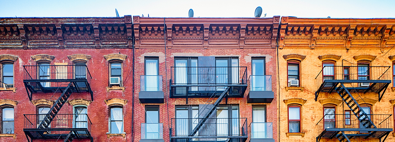 Row of urban apartment buildings with fire escapes