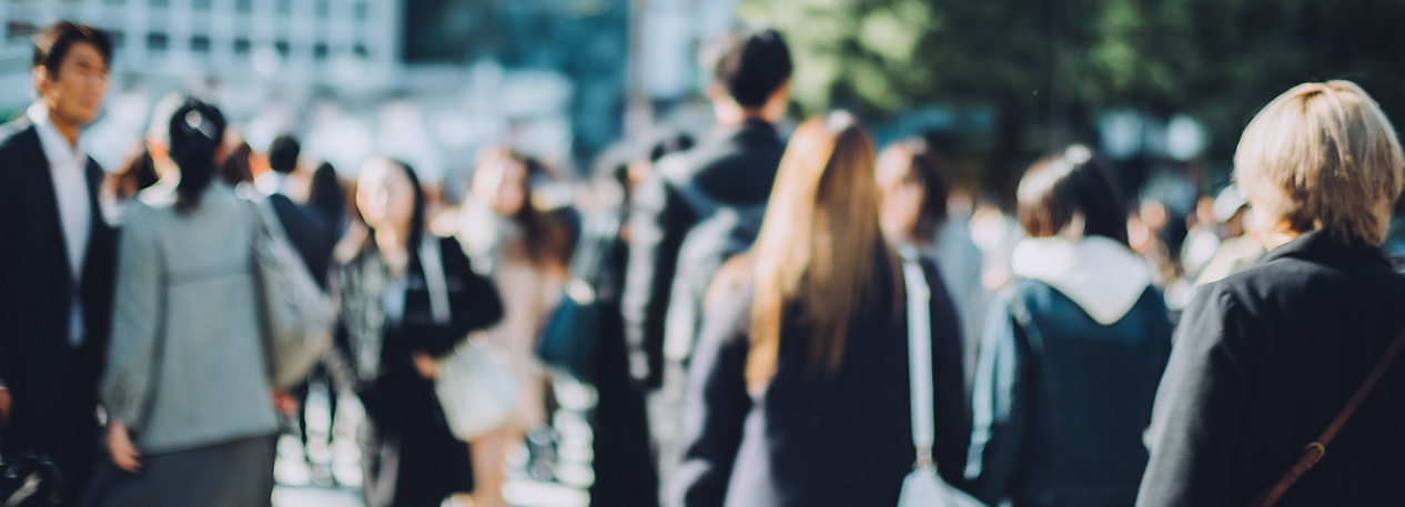 Blurred photo of pedestrians walking down a crowded street