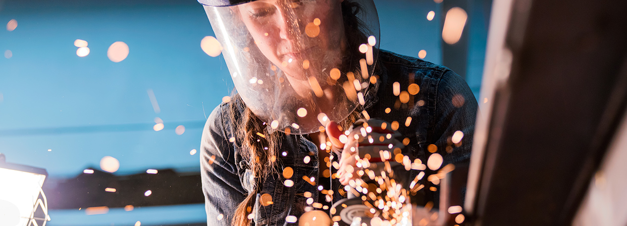 Woman in protective face shield using an angle grinder