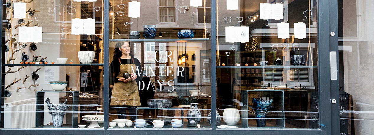 Woman looking out of the window of a boutique storefront