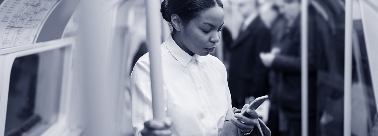 Woman on subway train looking at her cell phone