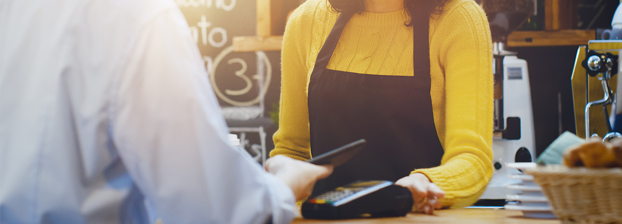 Man paying with a cell phone at a coffee shop