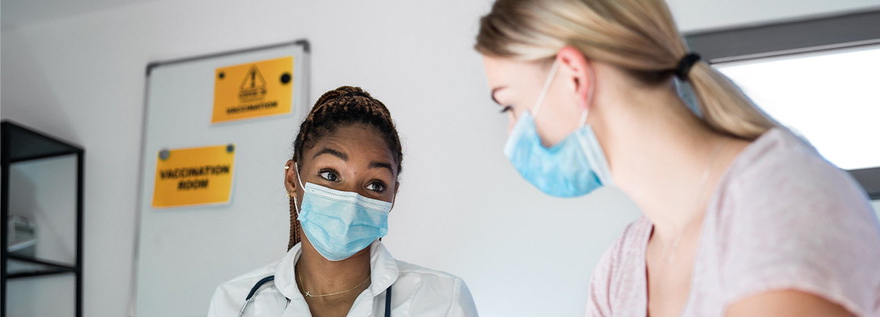 A woman wears a face mask getting while she waits to get vaccinated.