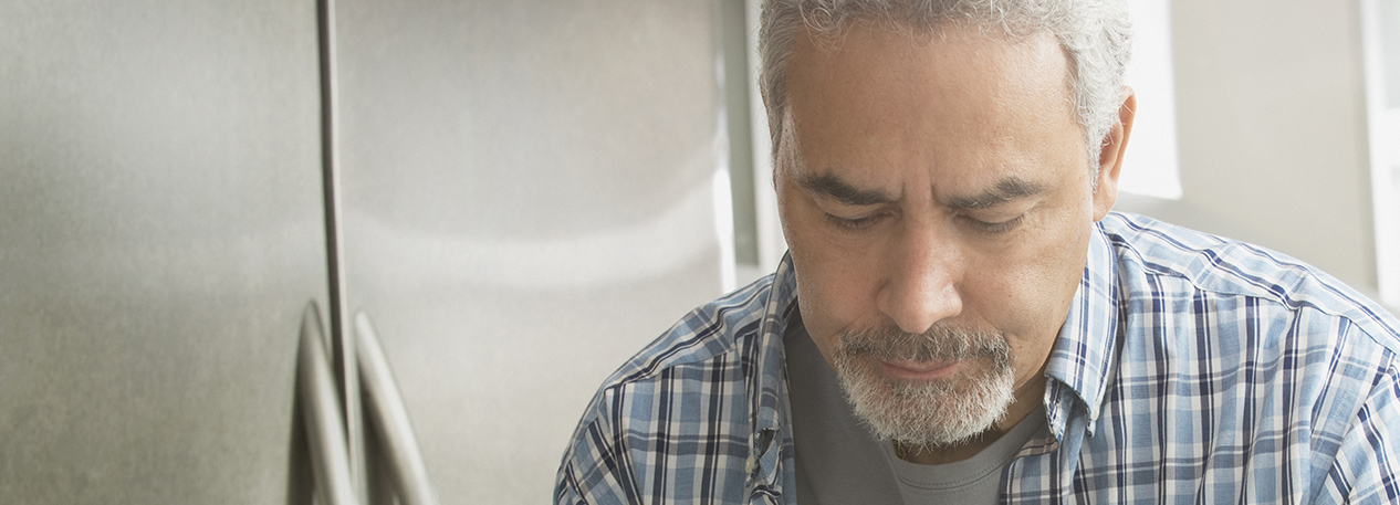 Middle-aged man paying bills in a kitchen